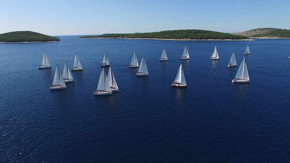 Voiliers naviguant au large d'une côte méditerranéenne